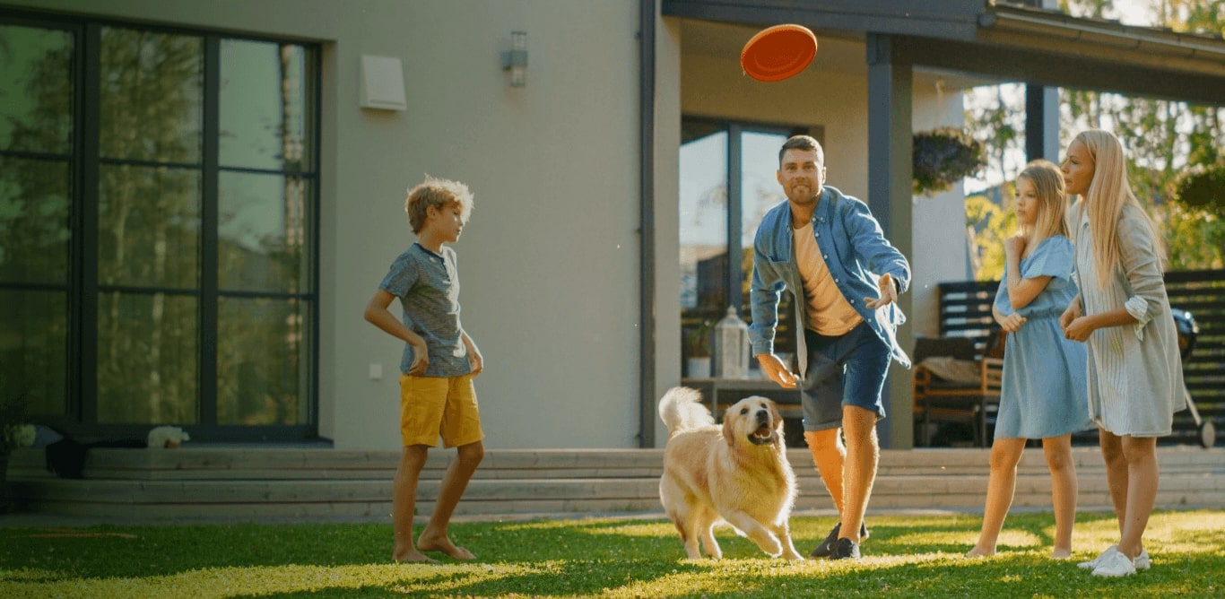A person playing Frisby with kids and dog
